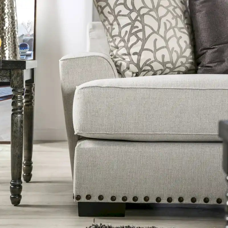 Canapé 3 places en tissu gris clair avec clous décoratifs et coussins décoratifs, style transitionnel