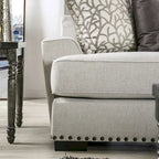 Canapé 3 places en tissu gris clair avec clous décoratifs et coussins décoratifs, style transitionnel